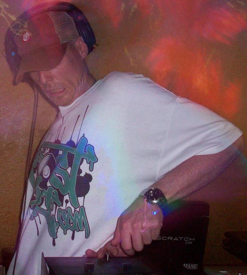 DJ Natural Nate® leaning into the mix under red and orange stage lights